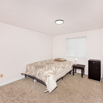 Private resident room with a bed and side table