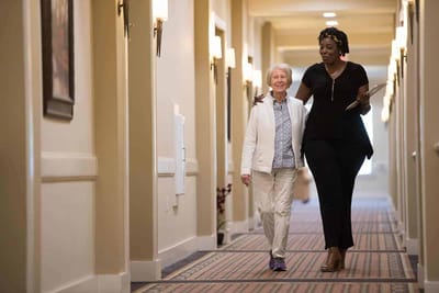 Staff member walking with resident in a hallway