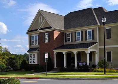 Exterior view of a senior living facility with people on the porch