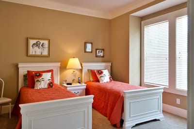 Cozy twin bedroom with orange bedding and window light