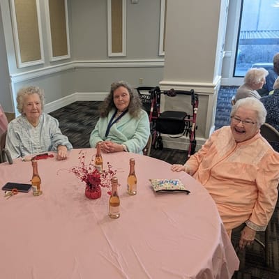 Three cheerful residents enjoying a gathering at a round table