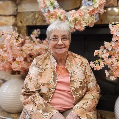A resident smiling among floral decorations