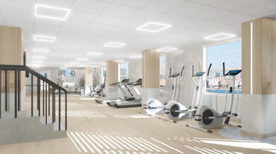 Well-lit gym area with exercise equipment and large windows