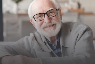 A senior man smiling in a brightly lit indoor setting