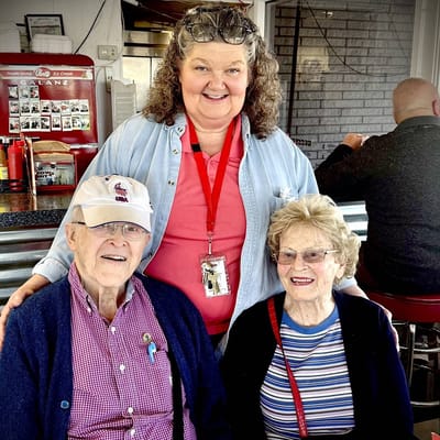 Staff member with two residents in a common area