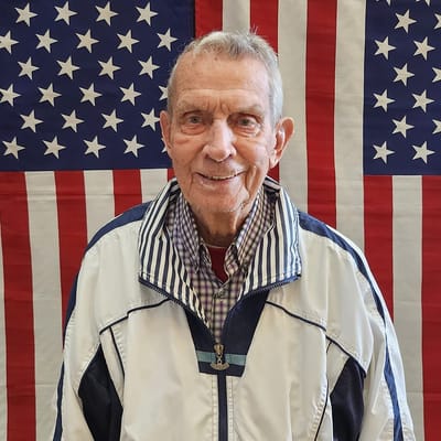 Senior resident smiling in front of American flag