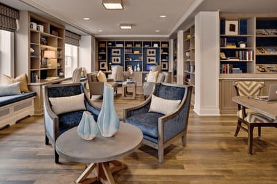 Bright and cozy interior common area with seating and bookshelves