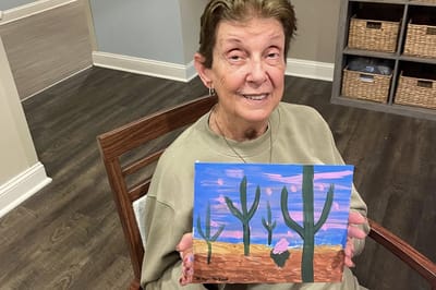Resident proudly displaying their artwork in a common area