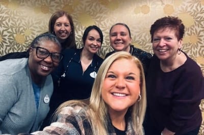 Staff members smiling together in a common area