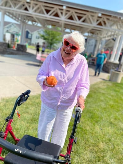 Resident enjoying a sunny day outdoors with a toy