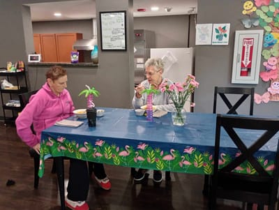 Two residents enjoying a meal at a decorated table