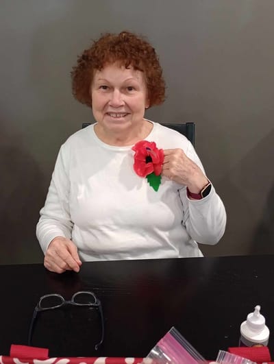 Resident with a flower pin, seated at a table