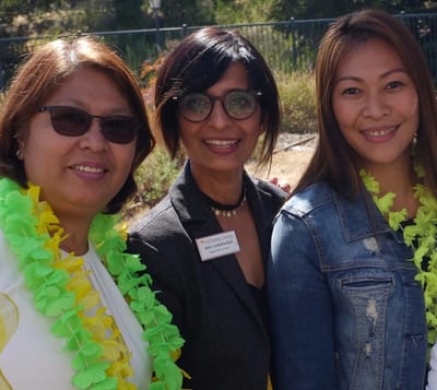 Three staff members smiling in a garden setting