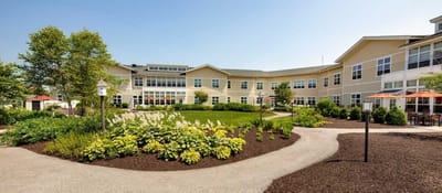 Exterior view of the assisted living facility with gardens