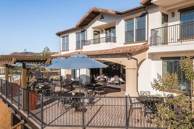 Outdoor seating area with restaurant-style tables and umbrellas
