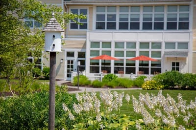 Exterior view of the facility with gardens and birdhouse