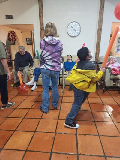 Residents participating in a lively activity with pool noodles