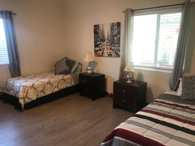A shared resident room with two beds and natural light