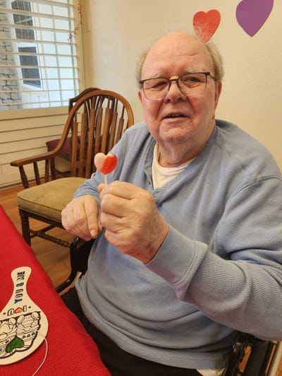 Resident enjoying a craft activity with a lollipop