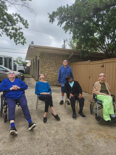 Residents enjoying a sunny day in outdoor seating