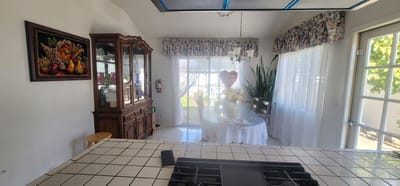 Bright dining area with flowers and white curtains