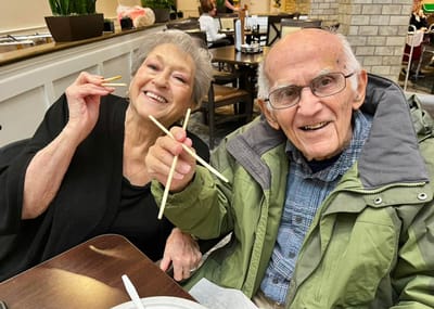 Residents enjoying a meal together while using chopsticks