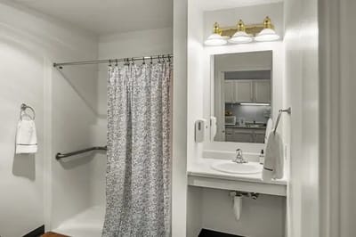 A private bathroom with a shower and sink