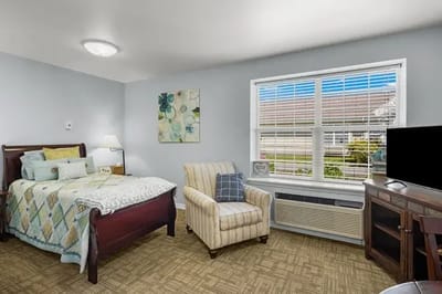 Cozy resident room with a bed and armchair