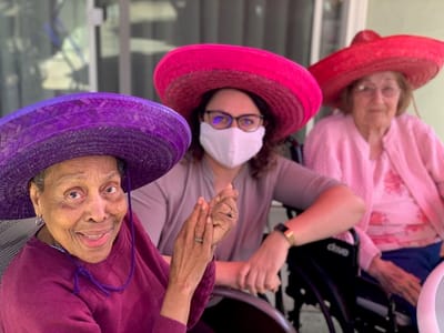 Residents and staff celebrating with colorful hats