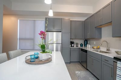 Modern kitchen with gray cabinetry and floral centerpiece