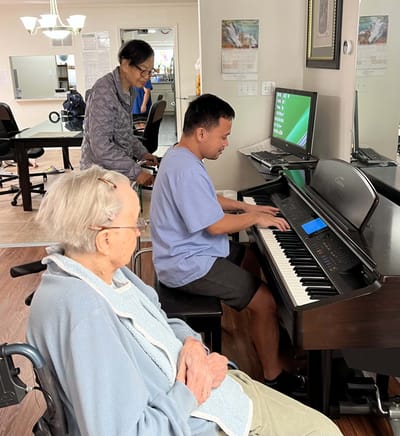 Residents enjoying a piano performance in an activity room