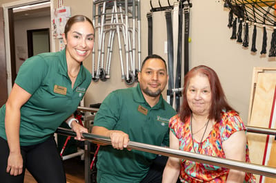 Staff assisting a resident in a therapy setting