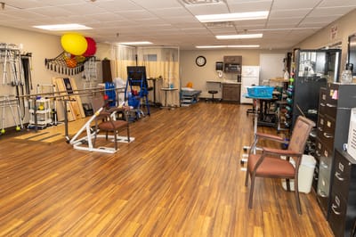 Rehabilitation room with therapy equipment and hardwood floor