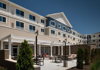 Exterior view of a senior living facility with outdoor seating