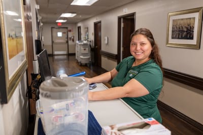 Staff member smiling at reception area