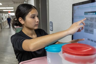 Staff member interacting with a digital screen