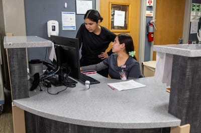 Two staff members collaborating at a reception desk