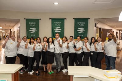 Staff members posing in a common area with flags