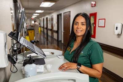 Staff member at a reception desk in a hallway