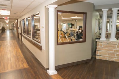 Interior view of a rehabilitation common area with equipment and people