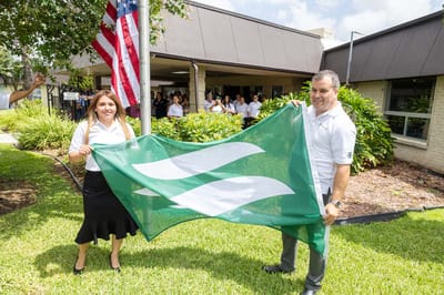 Staff members celebrating outside with a flag