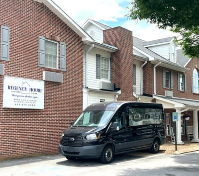 Exterior view of Regency House with facility transport van