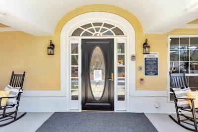 Entrance of Peachtree Creek Memory Care with rocking chairs
