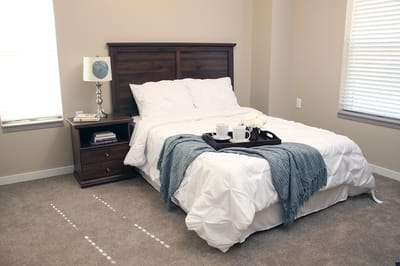 Cozy private resident room with a bed and bedside table