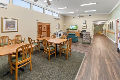 Common area with tables and seating in a senior living facility