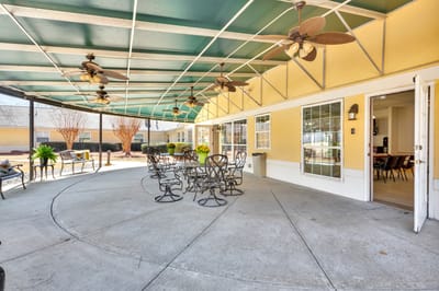 Outdoor seating area with tables and ceiling fans