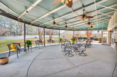 Covered outdoor seating area with fans and plants