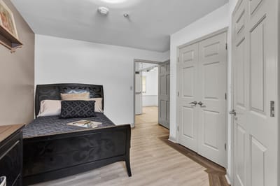 A private room with a bed and wood flooring