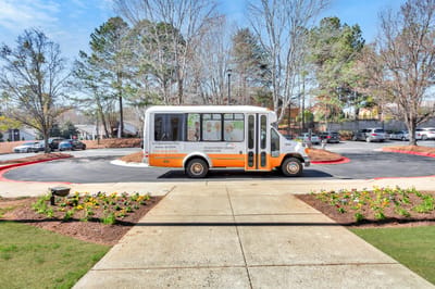 Facility shuttle bus parked in a landscaped area