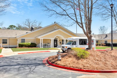 Exterior view of Peachtree Creek Memory Care facility with transportation van